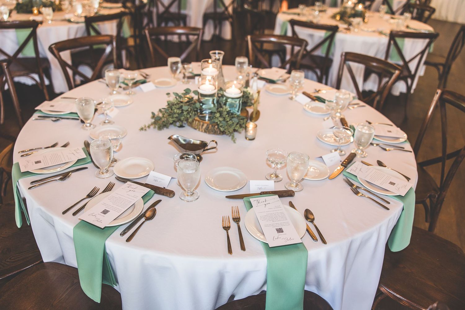 Elegant wedding reception tables set with mint green accents and white linens.