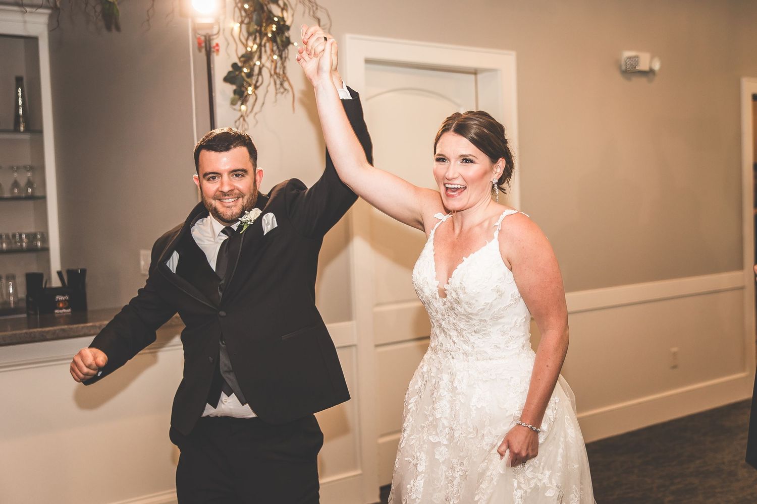 Couple dances together during their wedding reception in an elegant ballroom setting.