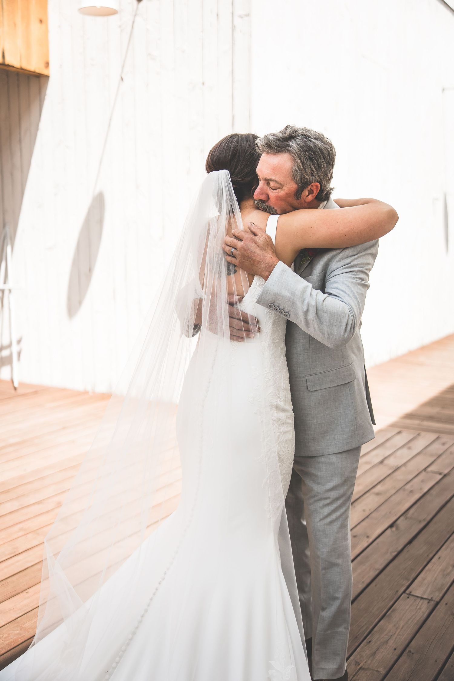 First look wedding moment captured through flowing white curtains.