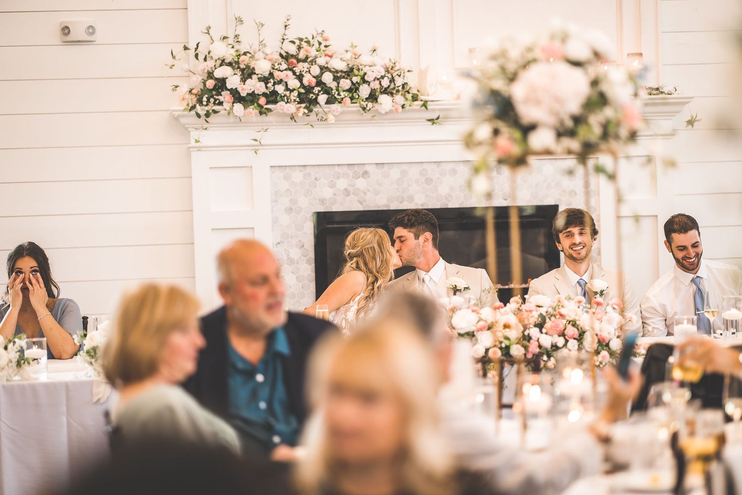 Wedding reception decor featuring white floral arrangements and elegant table settings.