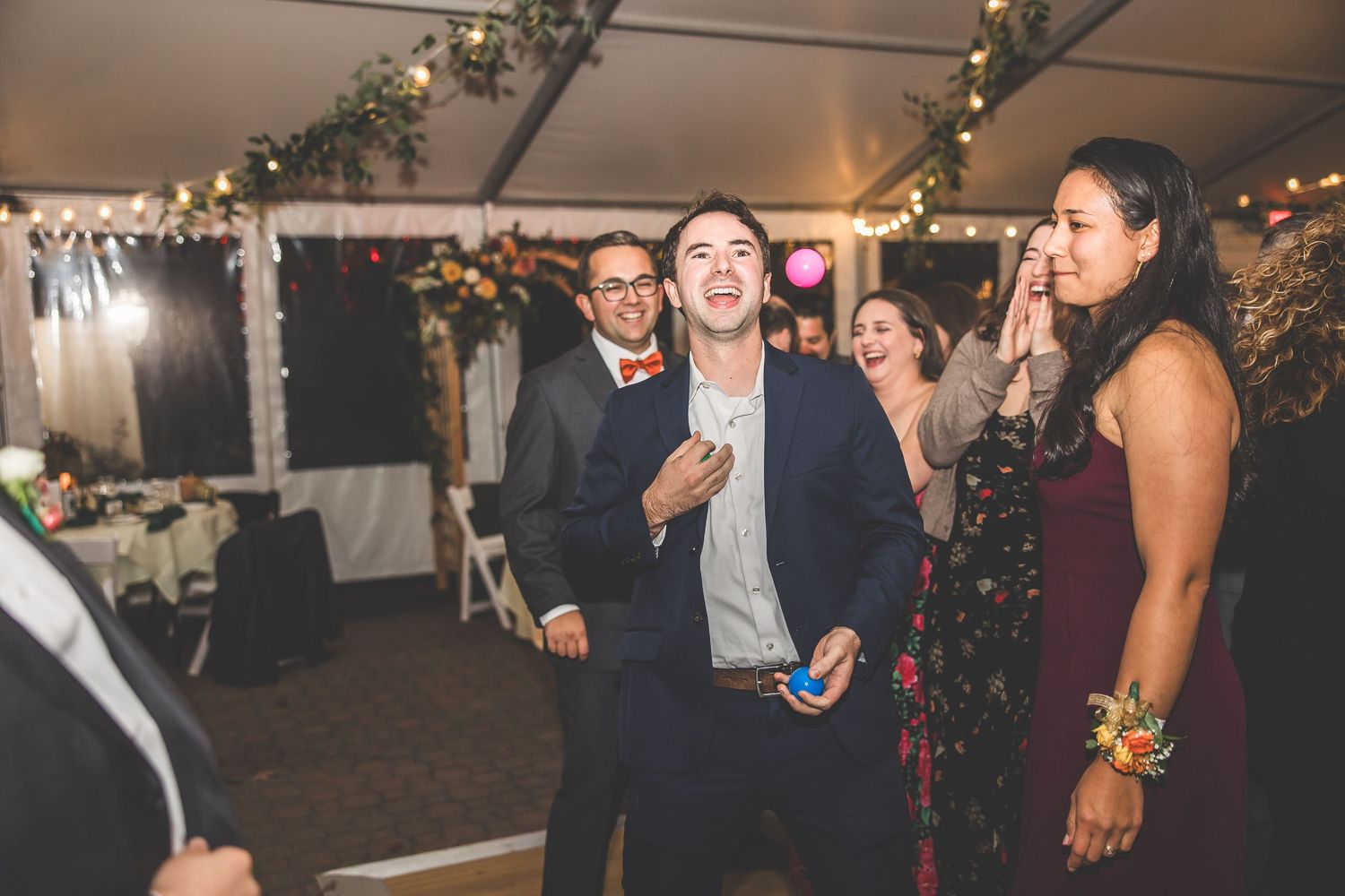 Wedding guests celebrate on the dance floor during an evening reception.