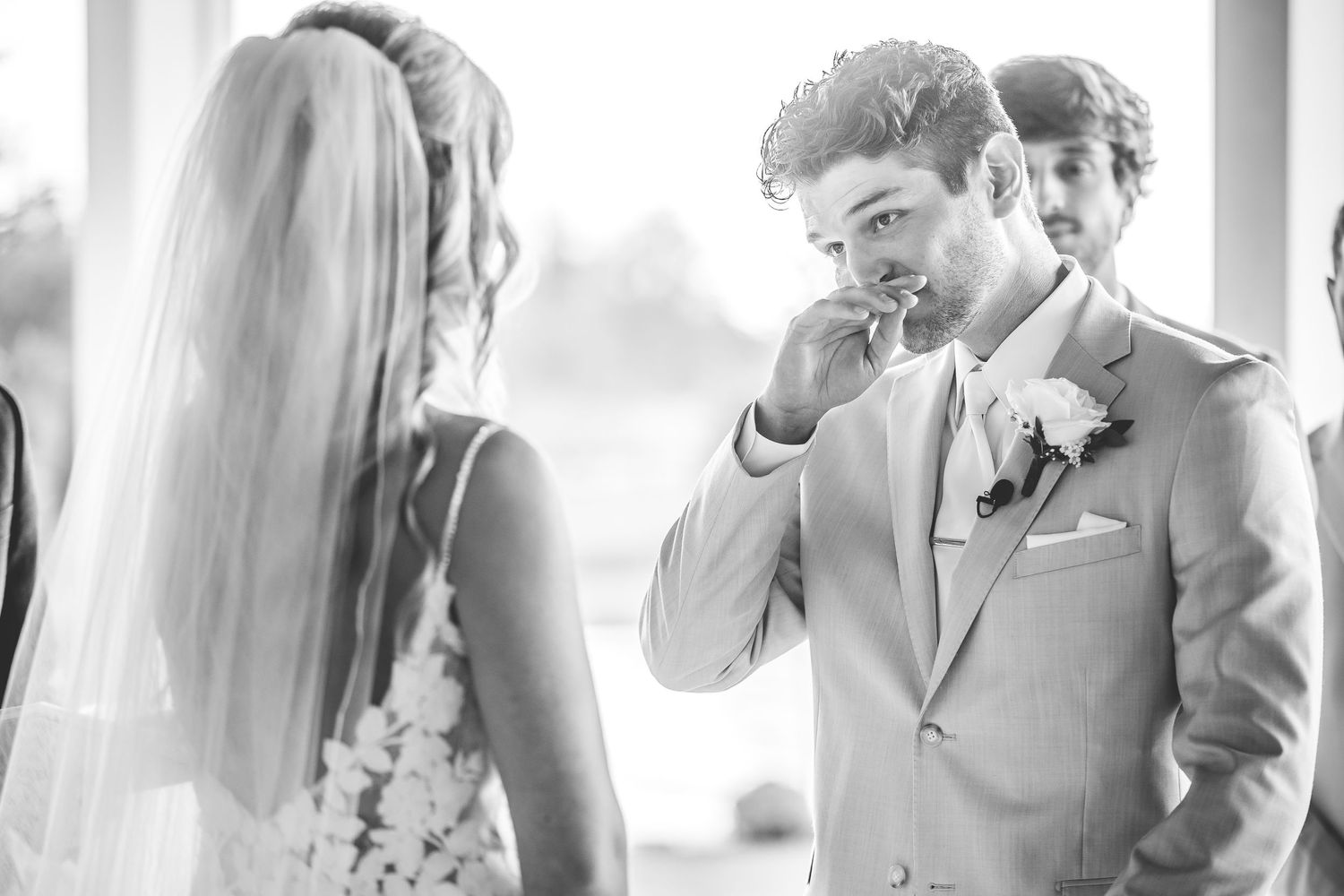 Wedding party members react emotionally during a first look reveal.