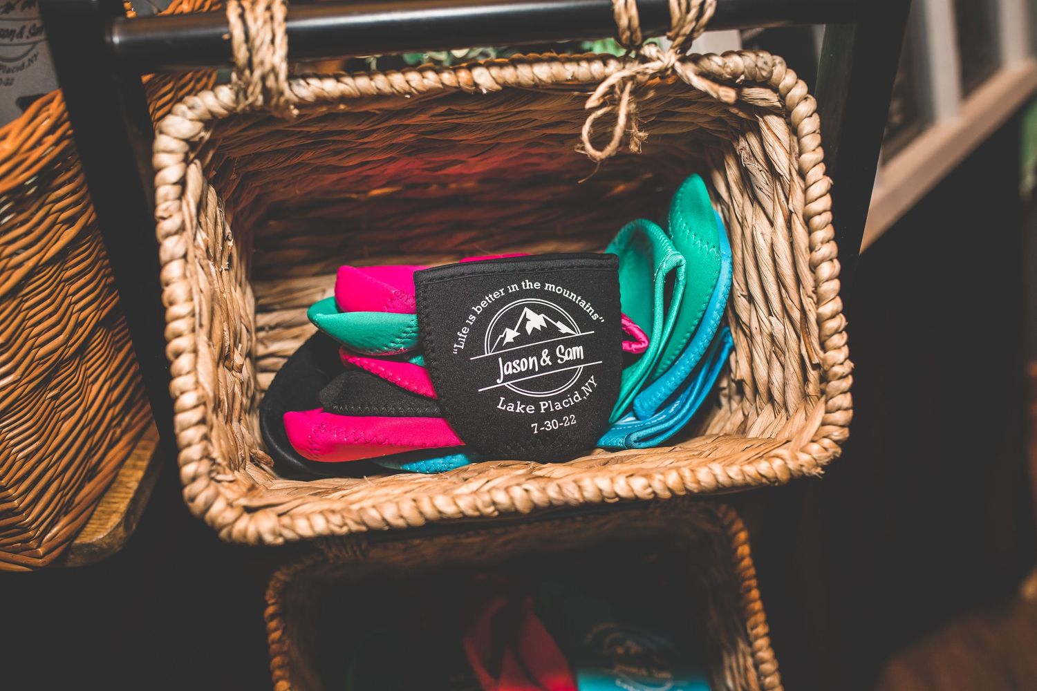 Woven baskets containing colorful wedding accessories displayed on wooden surface.