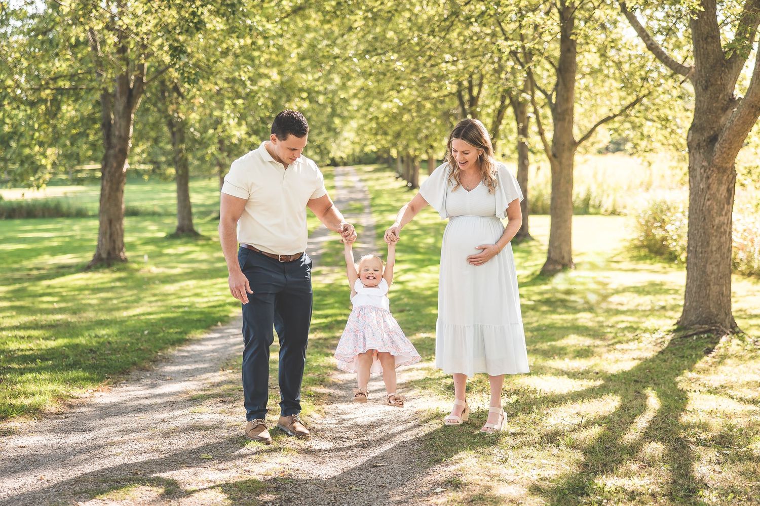 Family walking together on a tree-lined path during a summer evening.