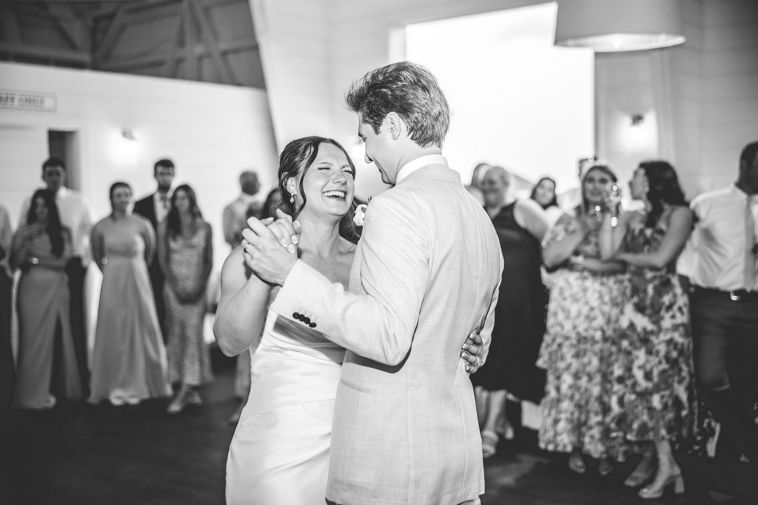 Wedding guests dance and celebrate on a rustic wooden dance floor.