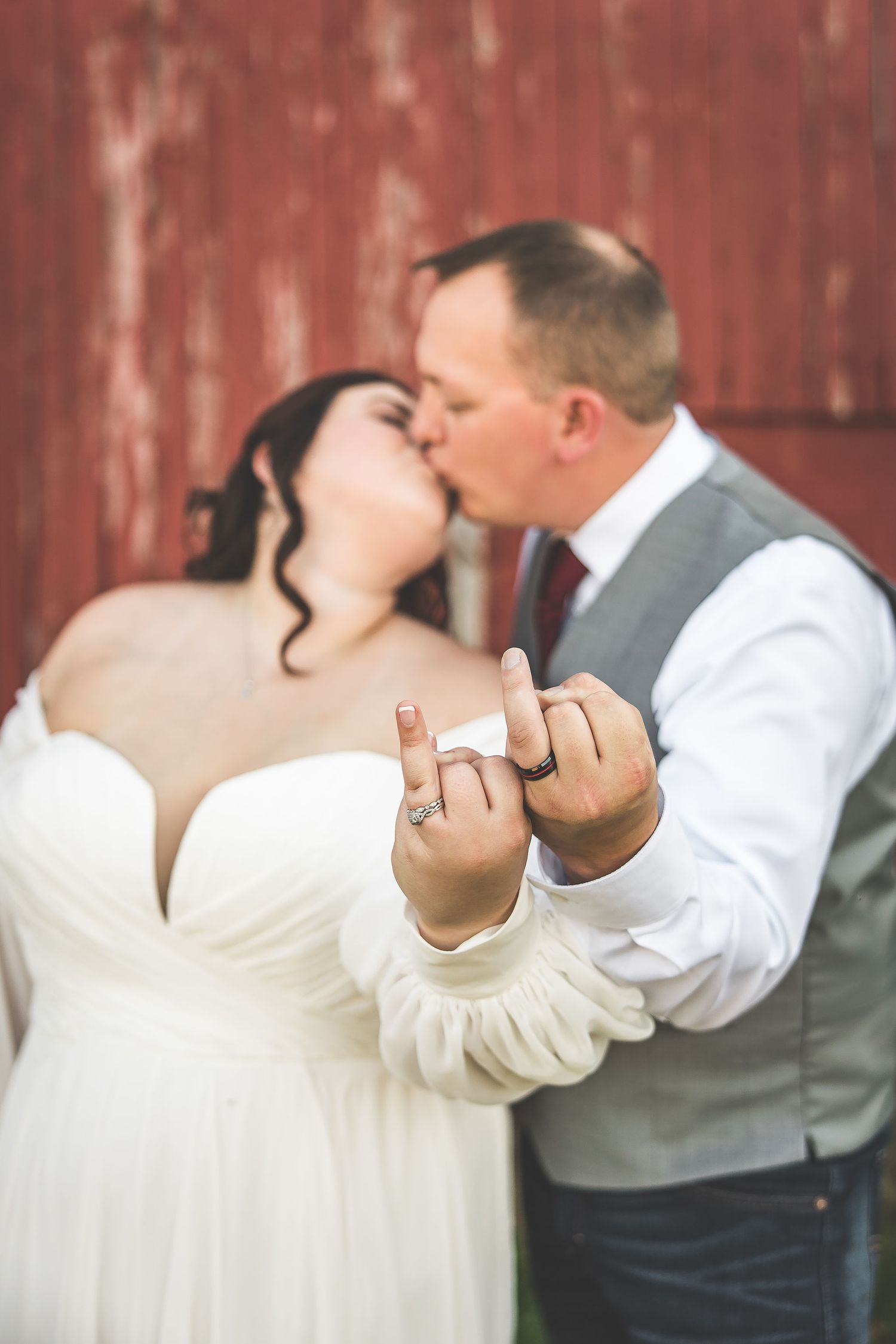Close-up shots of a romantic moment between newlyweds in front of a red barn.