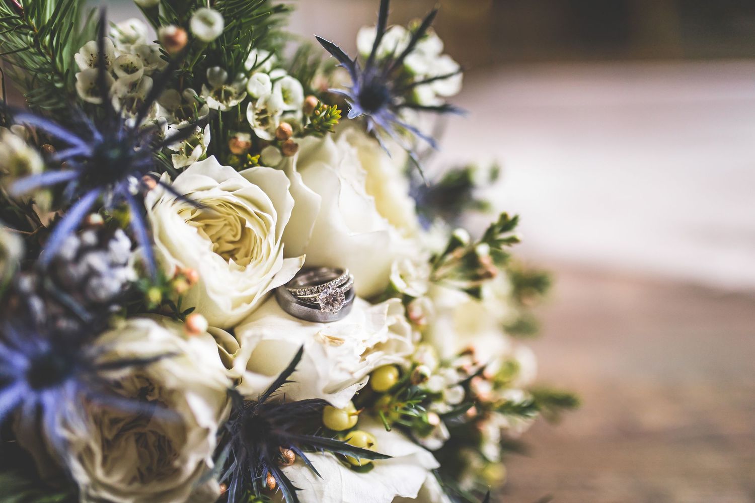 Close-up of white and blue wedding floral arrangements with delicate blooms and greenery.