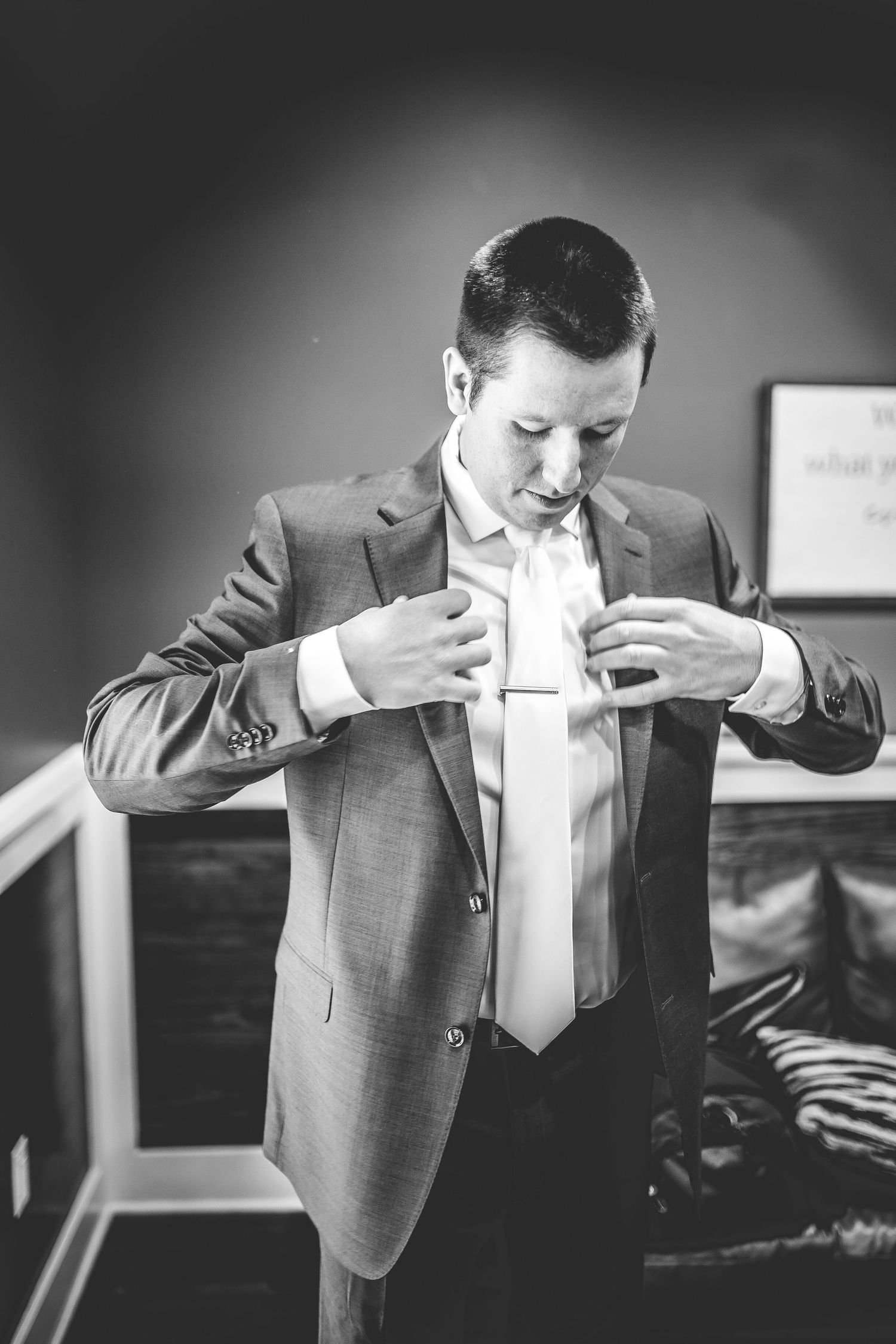 Black and white sequence of groom adjusting his suit jacket.