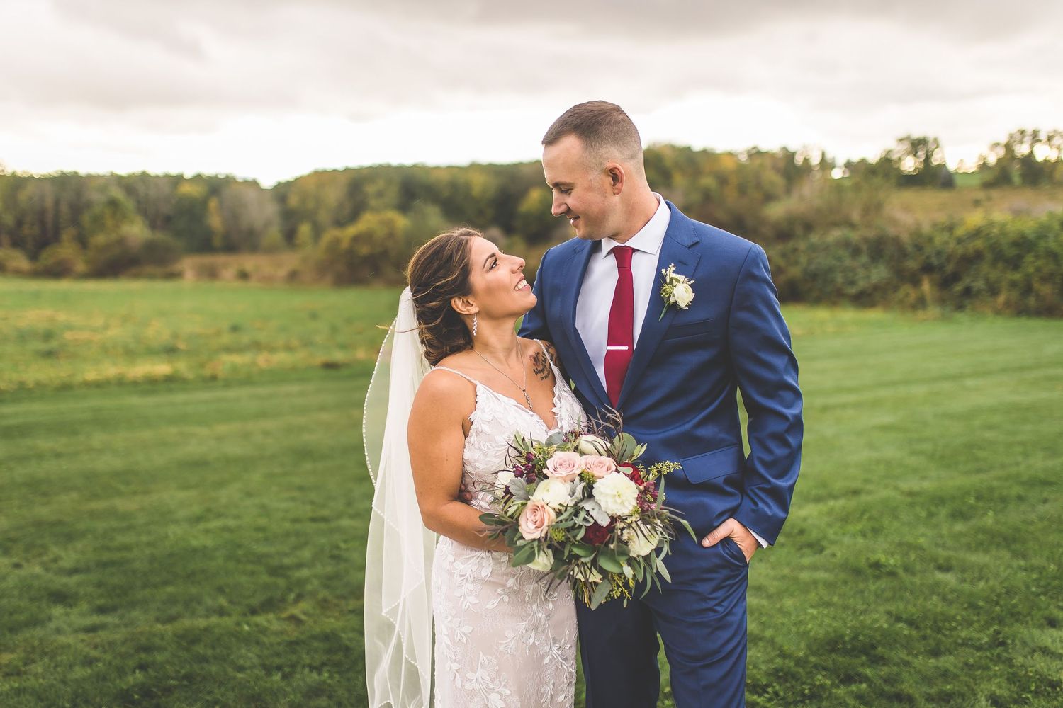 Elegant outdoor wedding photography session in a lush green field.