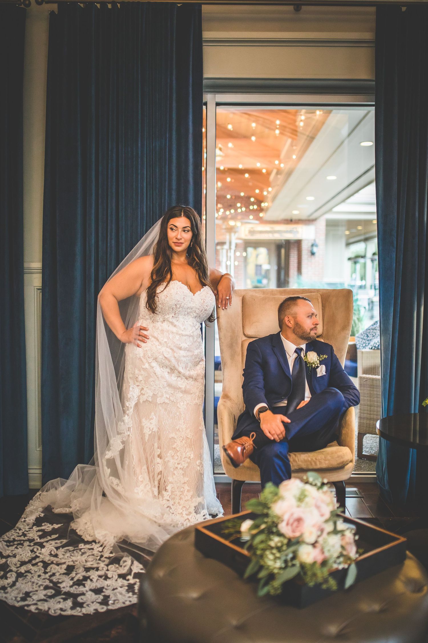Elegant wedding portrait in venue with string lights and luxurious decor.
