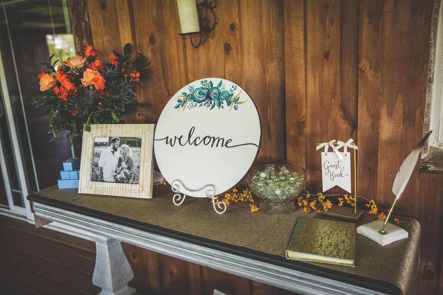 Rustic wooden wall decorated with welcome signs and wedding decor.