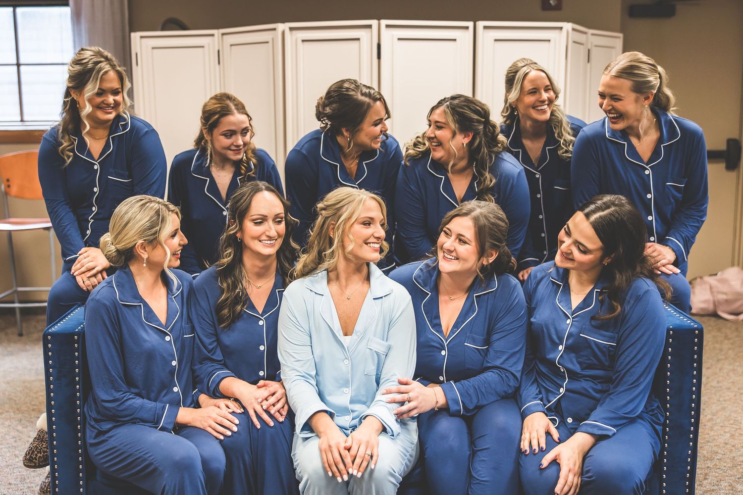 A group wearing matching navy blue outfits sits together sharing a joyful moment.