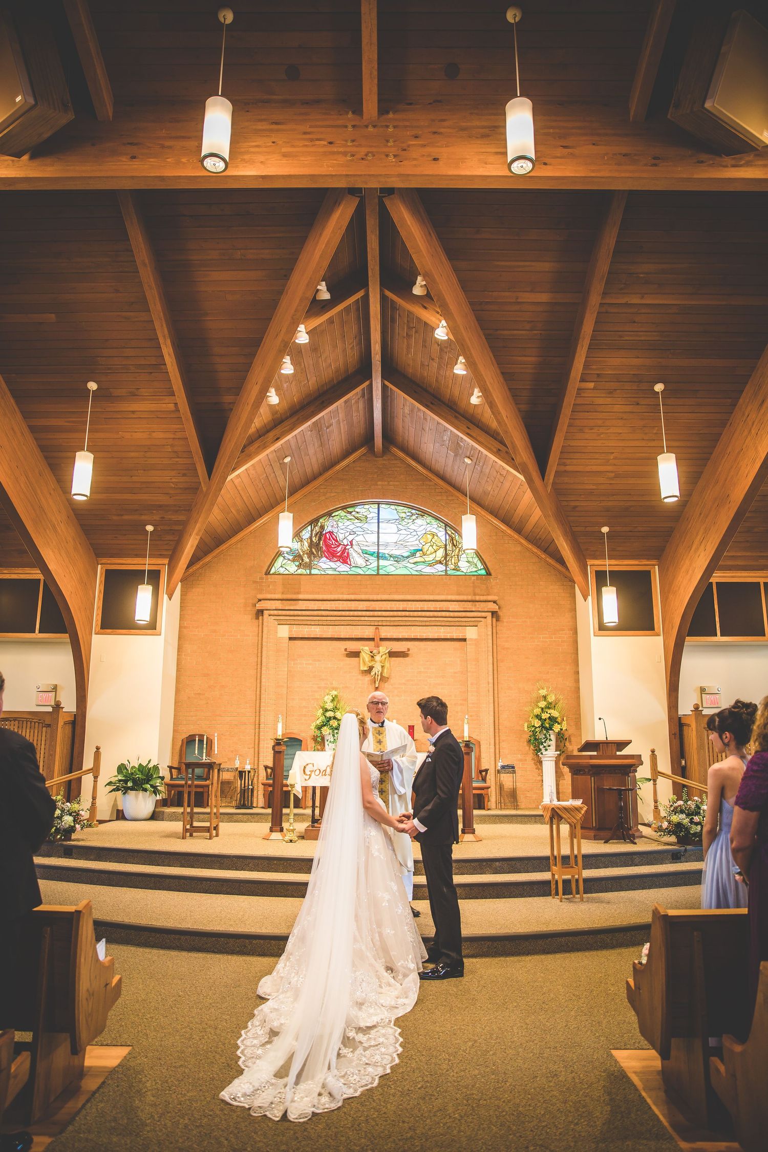 Panoramic view of church altar area during wedding ceremony.