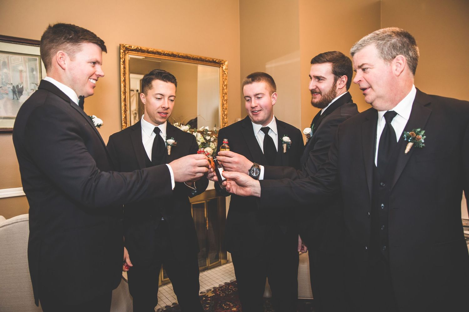 Groomsmen in black suits and ties gathered together before the ceremony.