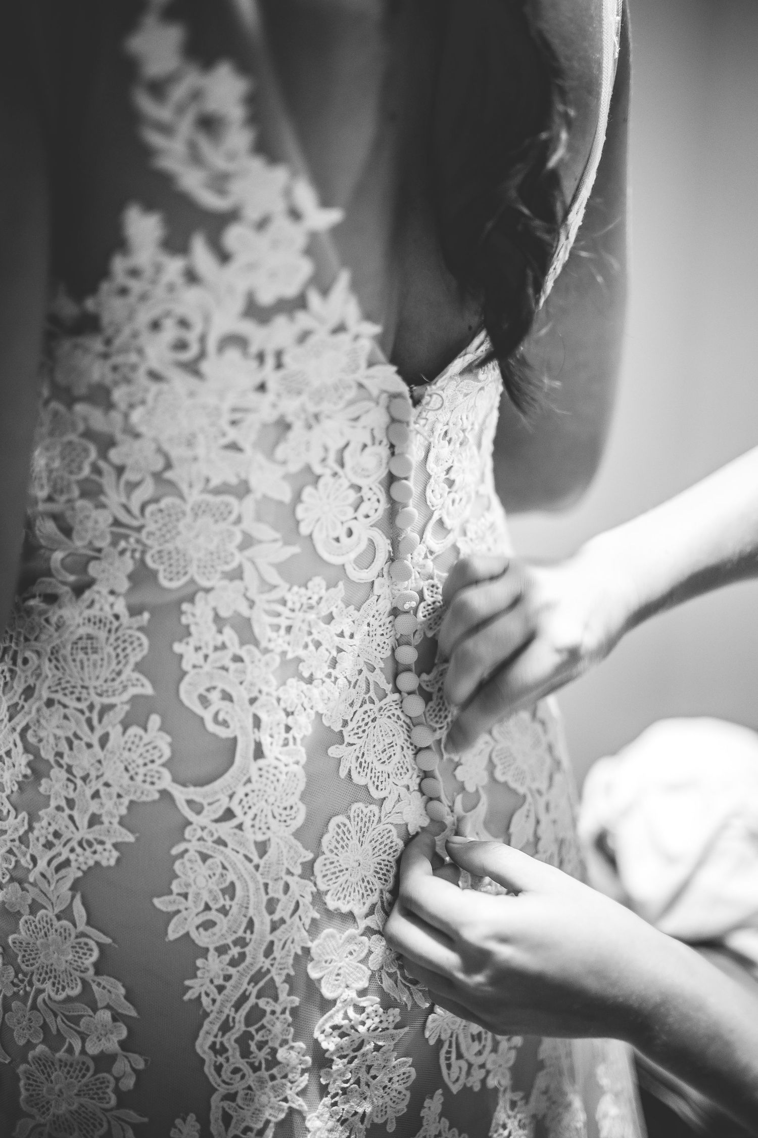 Close-up details of intricate white lace wedding dress pattern.