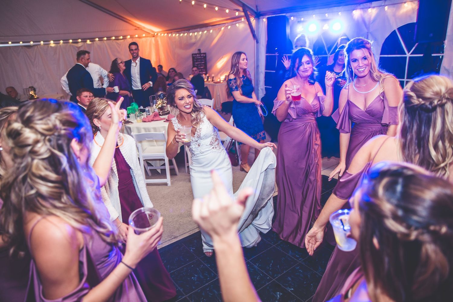 Wedding reception dance floor with colorful lighting and guests dancing.