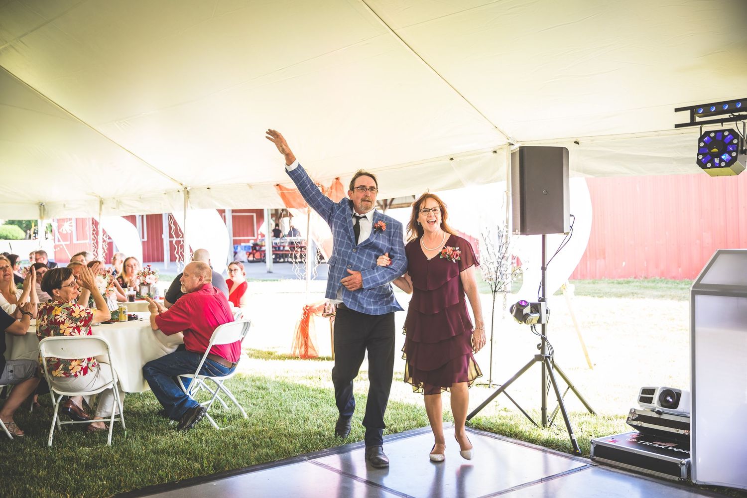 Wedding reception dance floor under tent with guests celebrating.