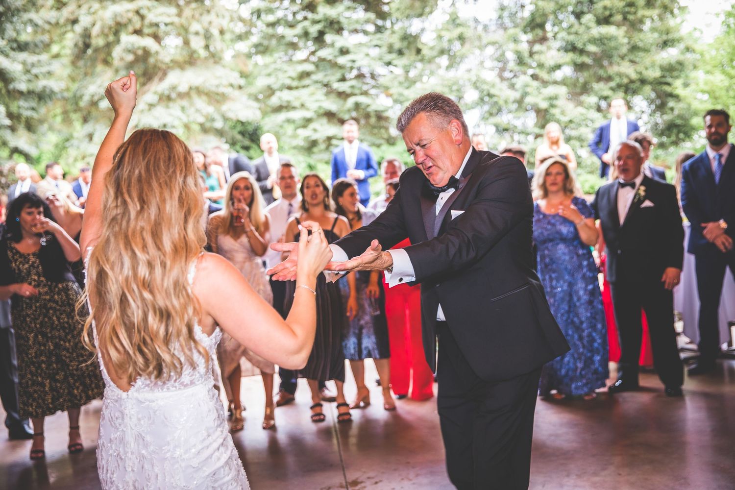 Wedding celebration with guests watching a special dance moment in an elegant indoor venue.
