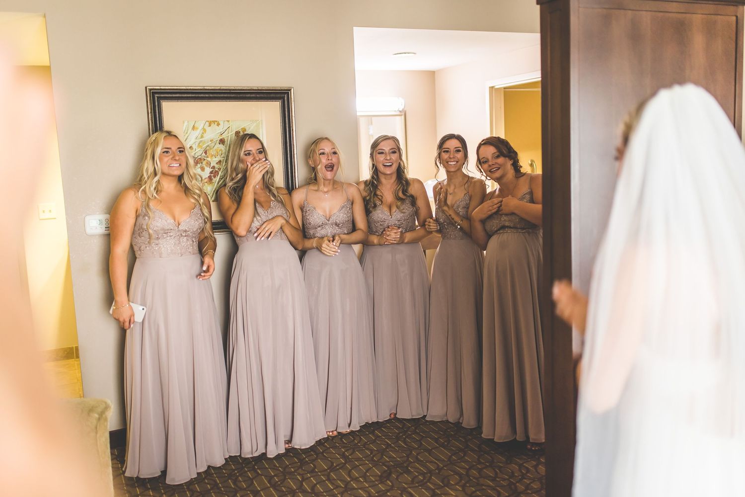 Bridesmaids in elegant gray dresses pose together at a formal wedding celebration.
