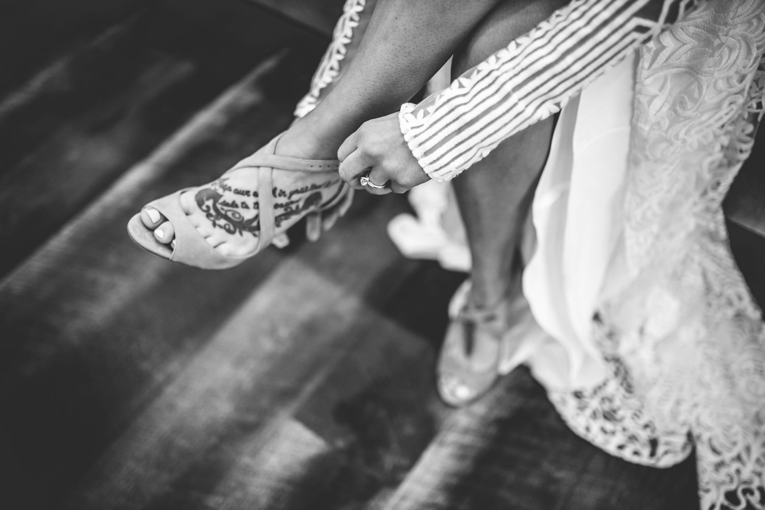 Close-up details of wedding shoes and accessories in black and white.