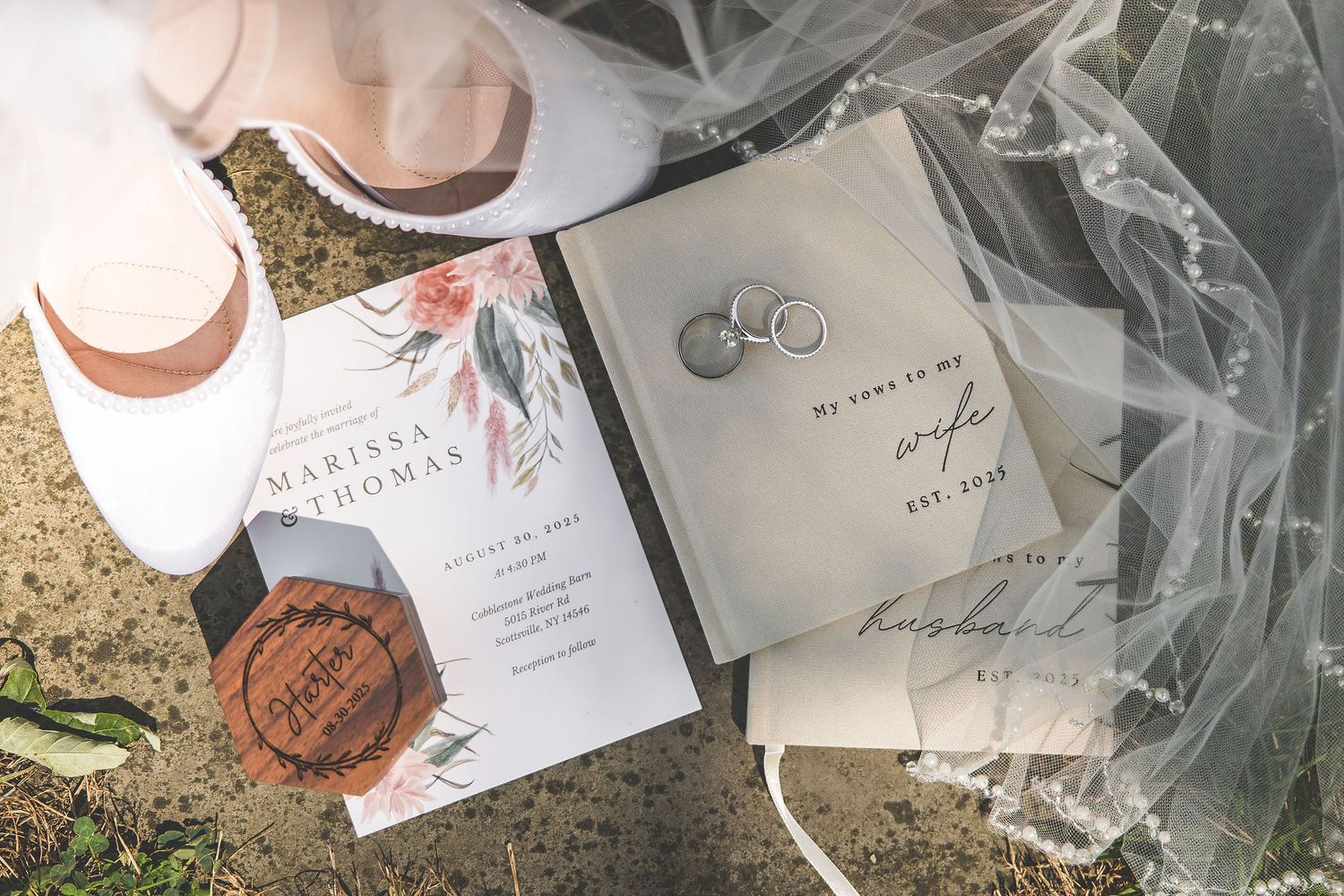 Wedding invitation and rings displayed on textured paper with elegant calligraphy and wax seal details.