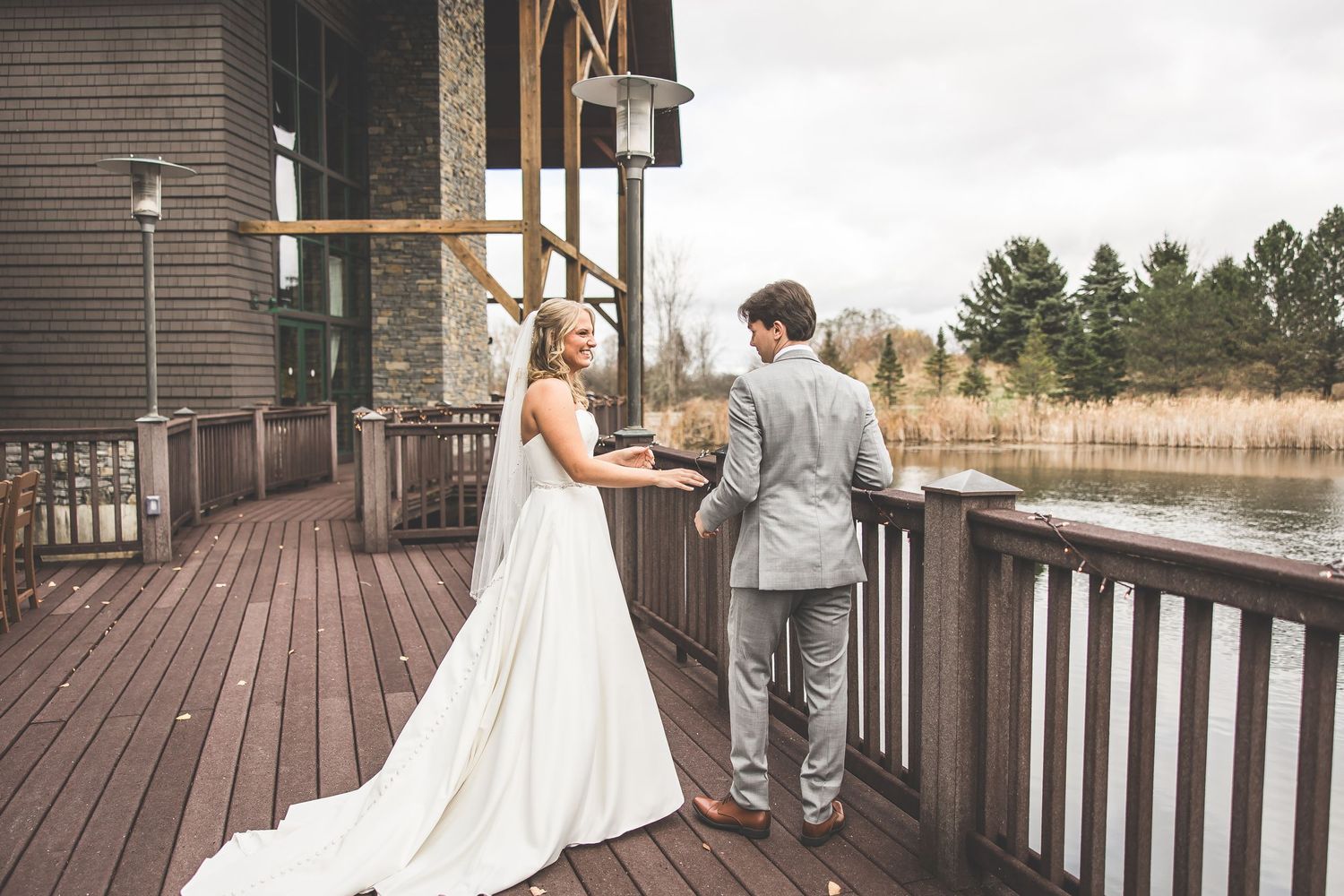 Romantic wedding couple embracing on a wooden deck with mountain views.