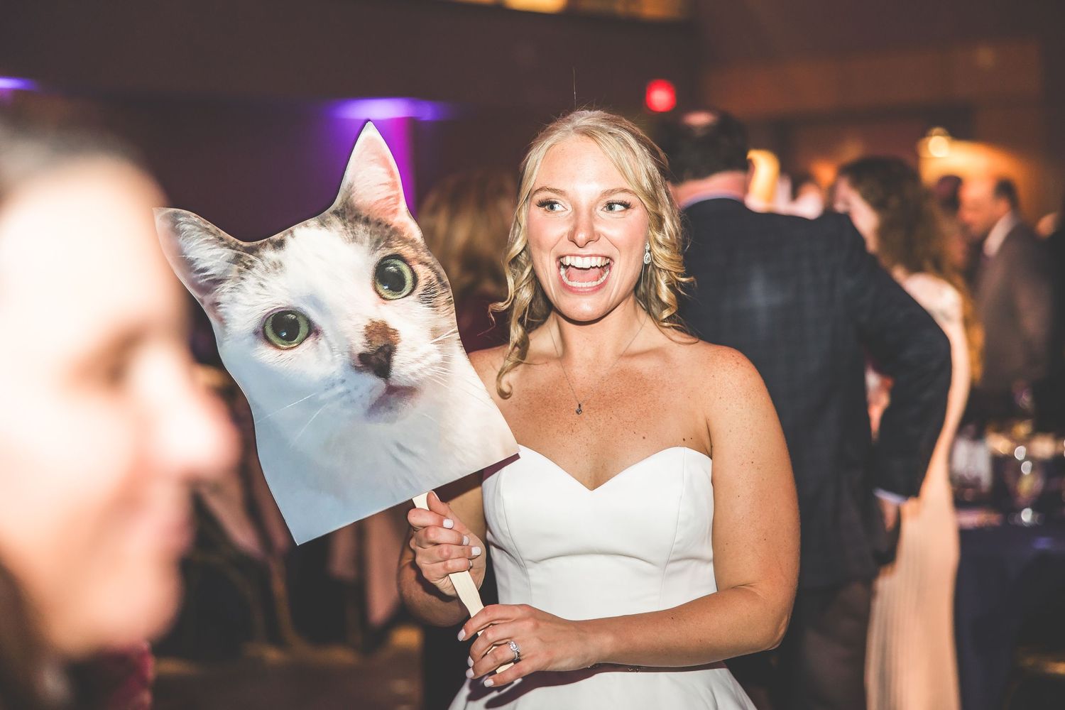 Wedding party members holding cats during a fun reception photo session.