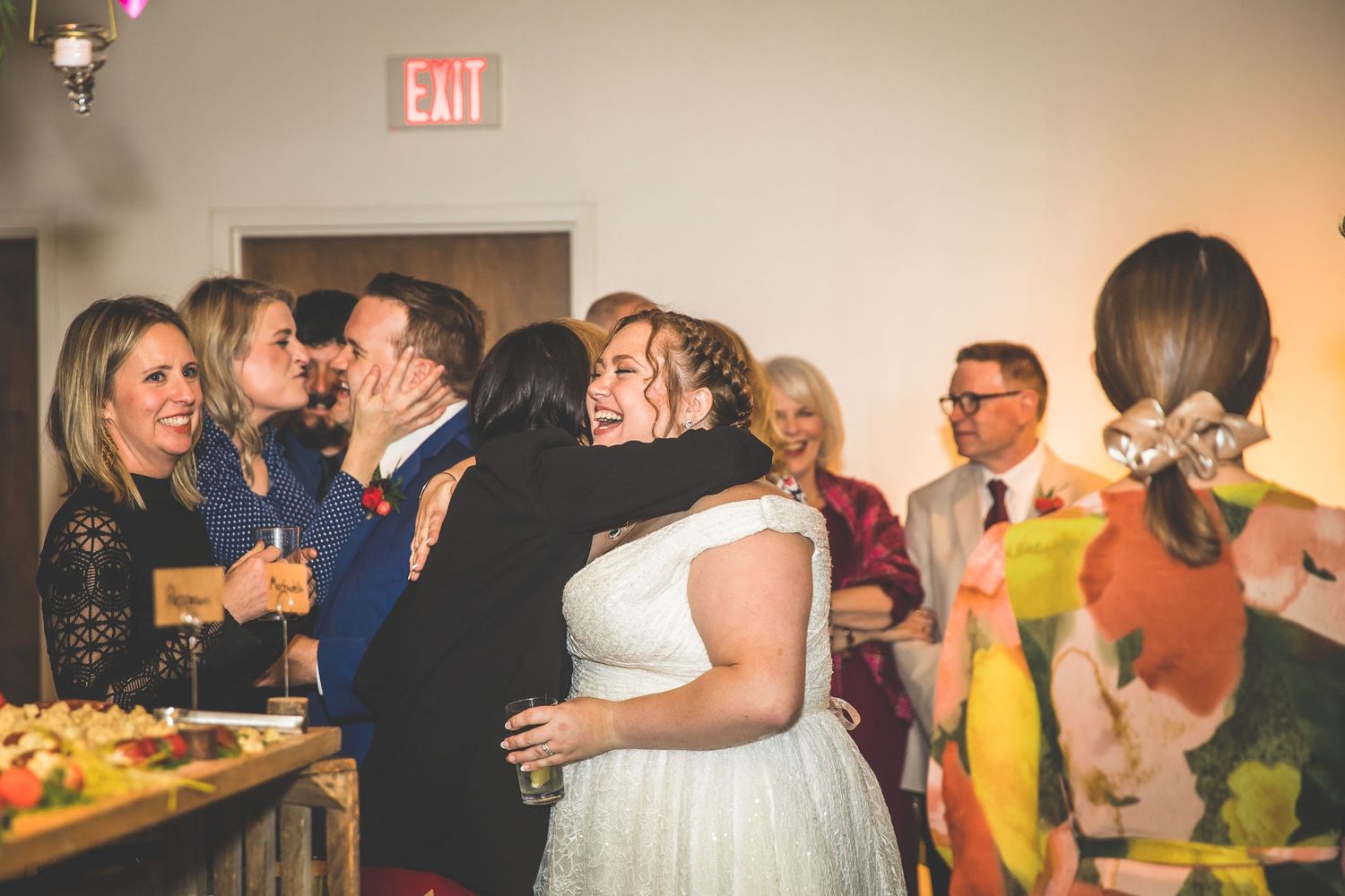 Wedding guests celebrate and dance during the reception under warm lighting.