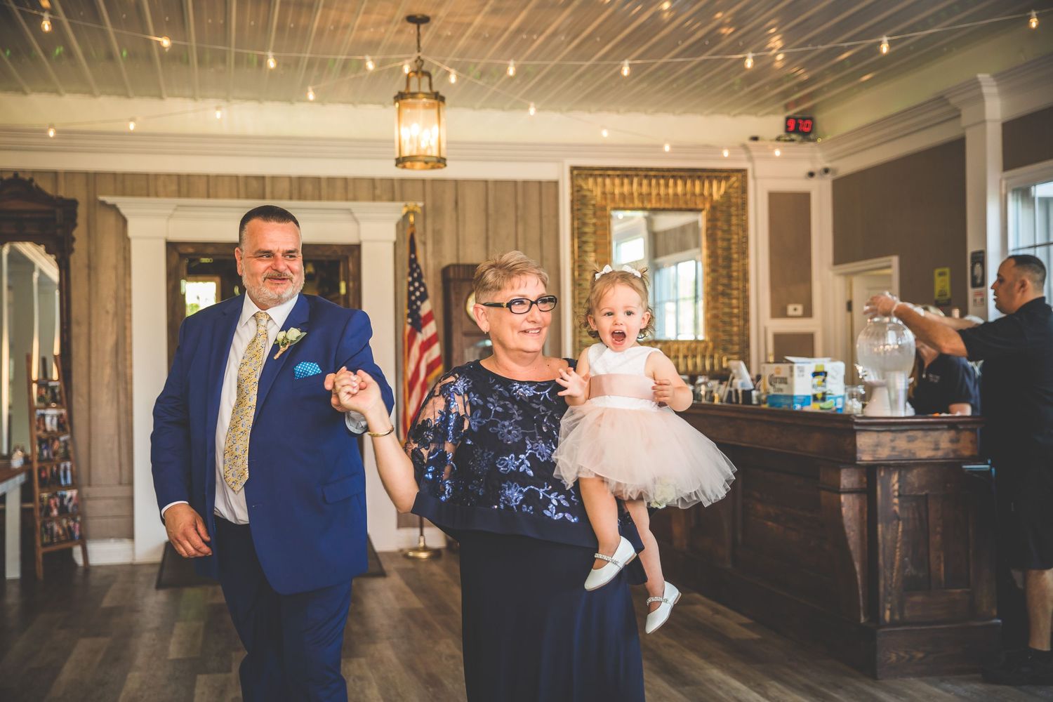 Wedding celebration scene in an elegant venue with American flag and formal decor.