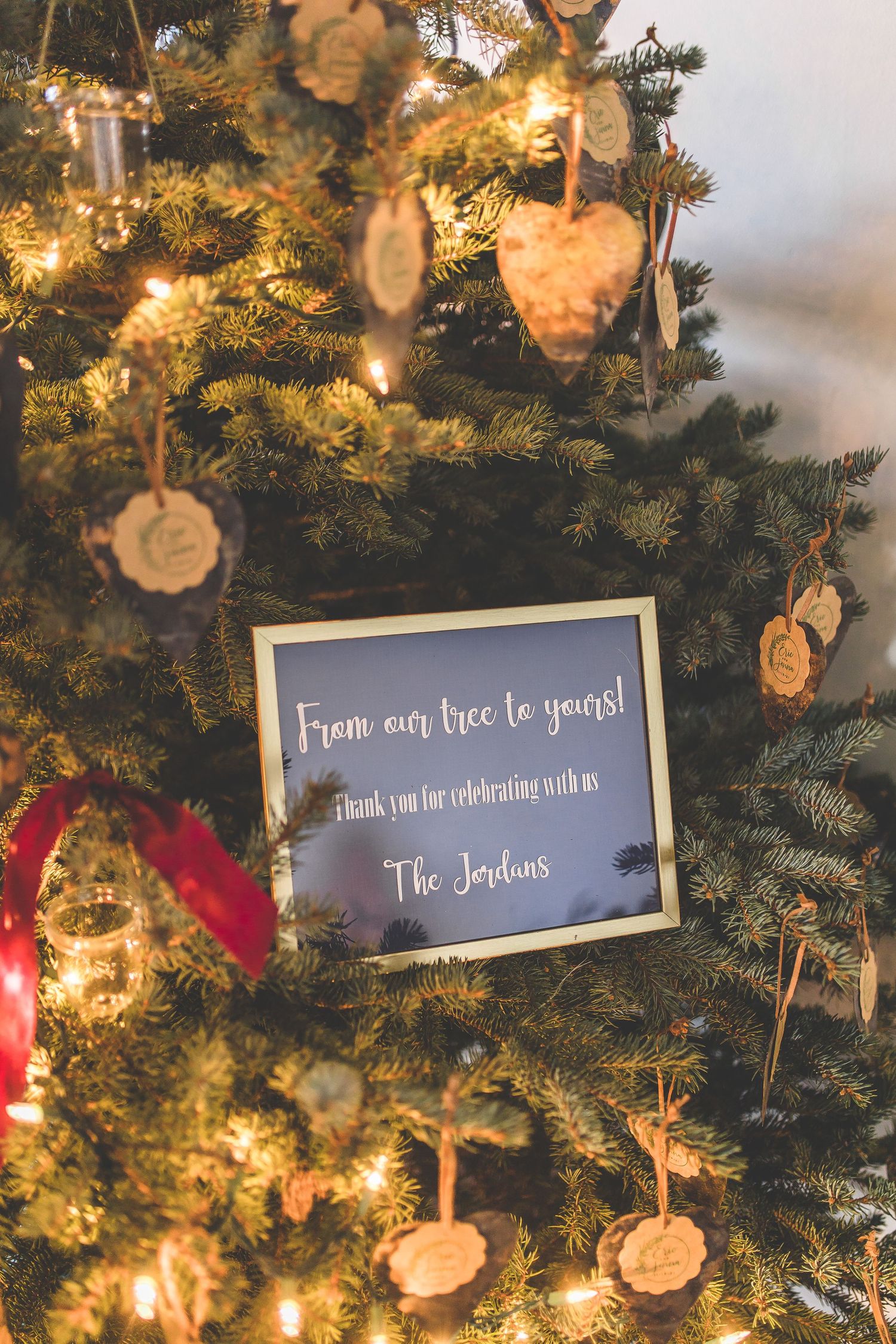 Decorated Christmas tree with illuminated signs and ornaments displaying wedding messages.