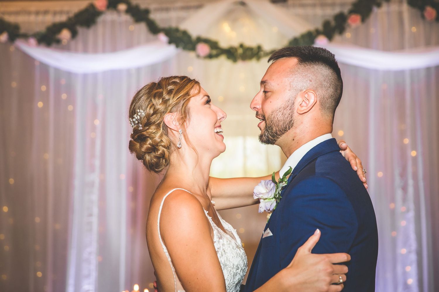 Joyful wedding dance moment captured in a beautifully decorated barn venue.