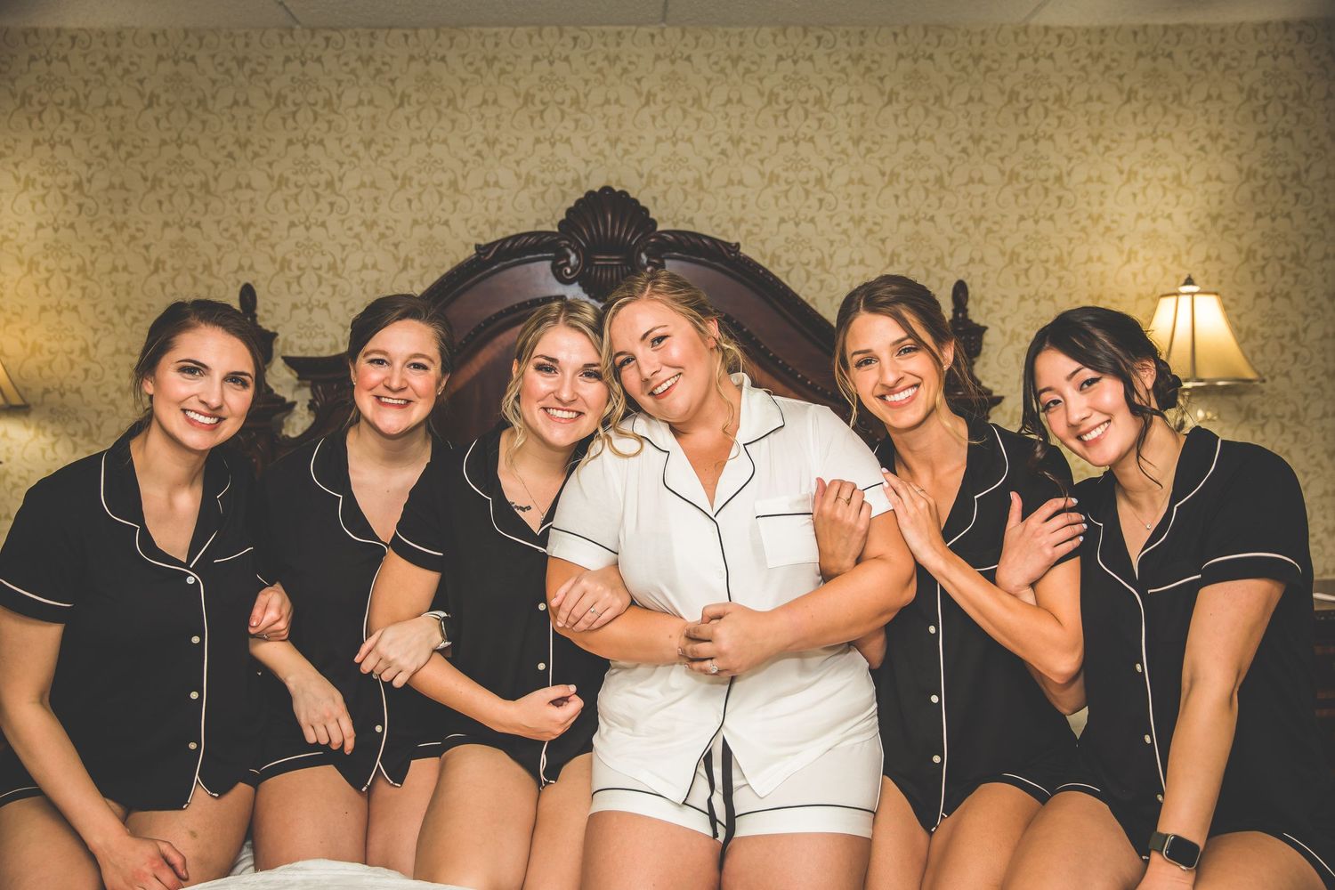 Bridal party in matching black outfits sharing candid moments together.