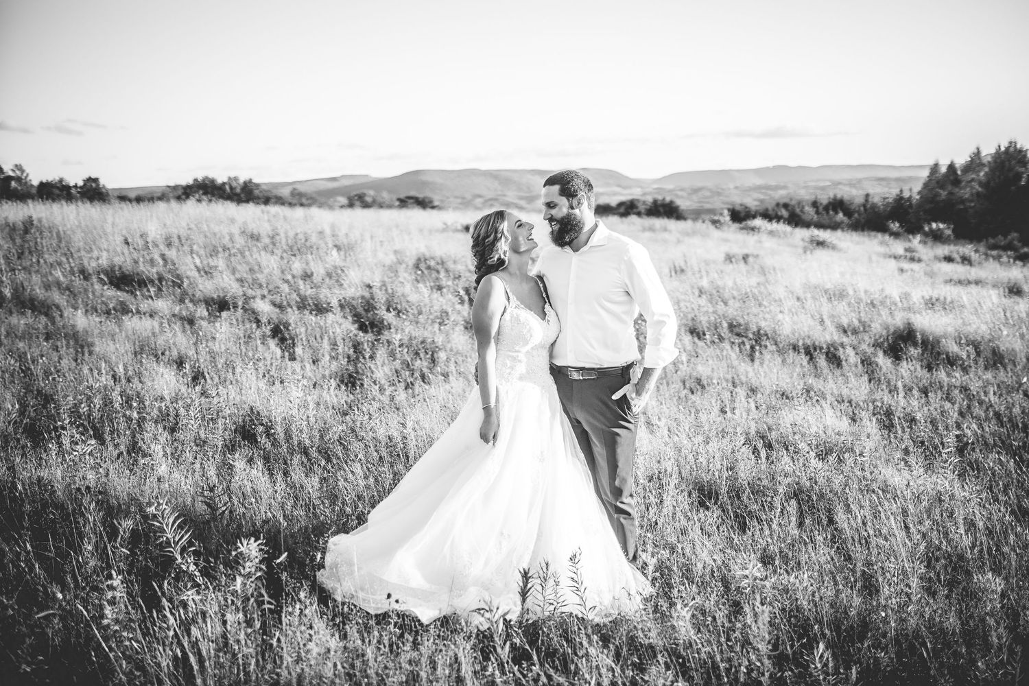 Black and white wedding portrait in a serene mountain meadow.
