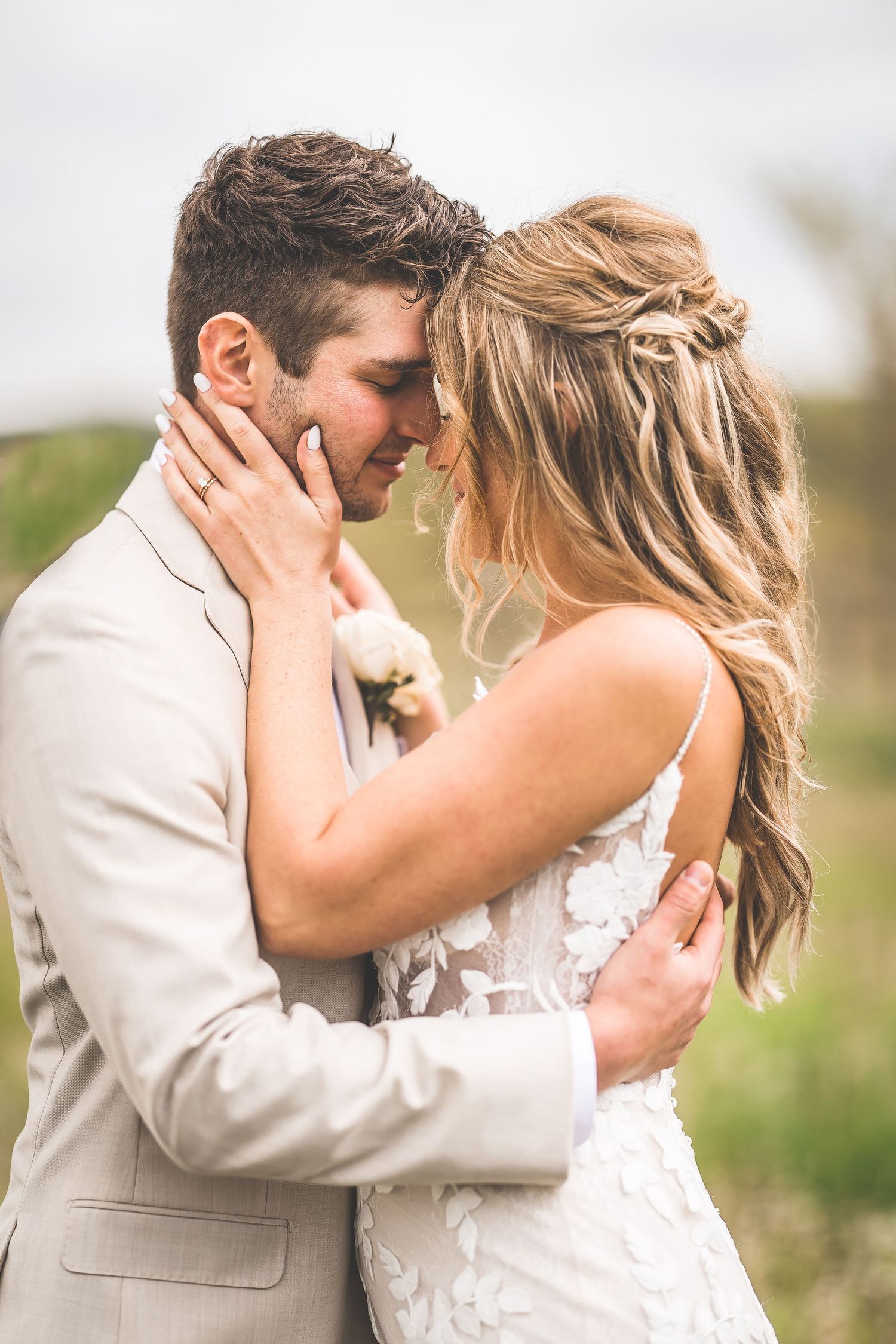 Close-up shots of a romantic wedding couple embracing in a natural meadow setting.