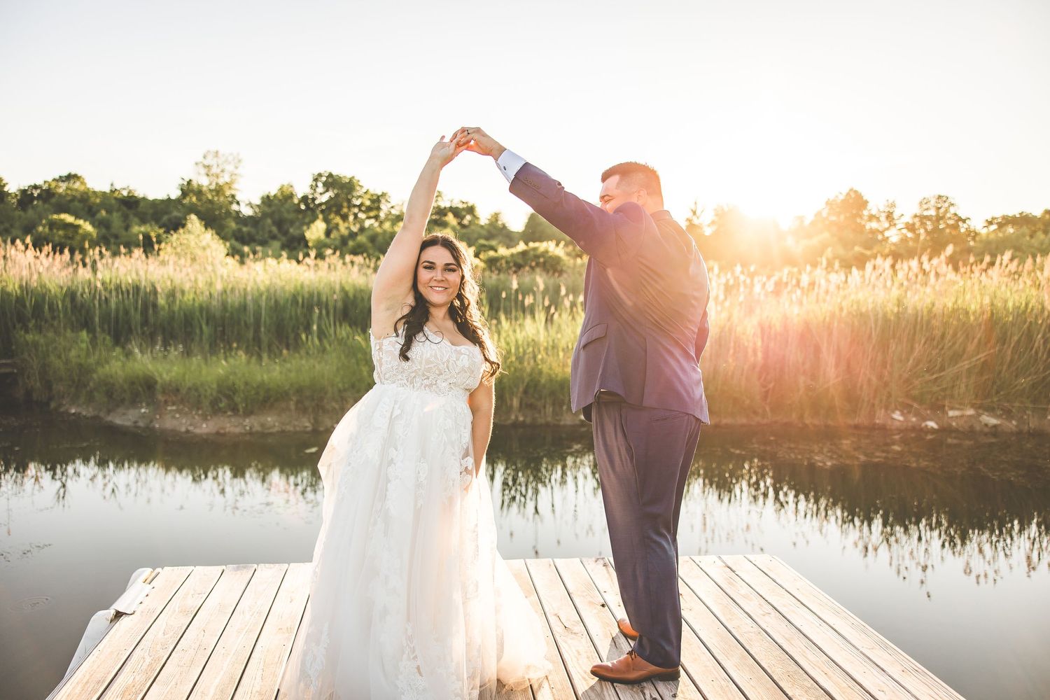 Romantic sunset wedding photos captured on a wooden dock by a serene lake.