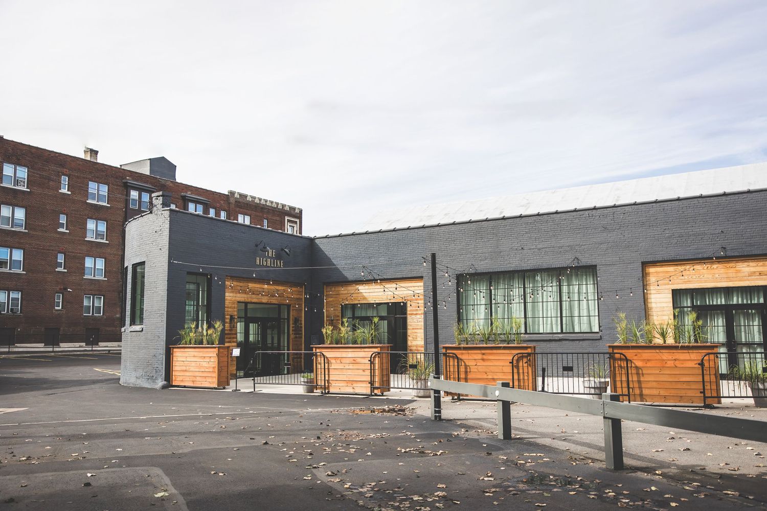 Modern storefront exterior with wooden planters and contemporary architectural design.
