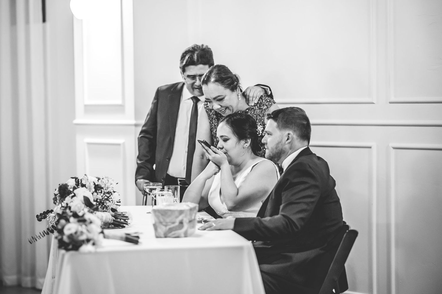 Black and white candid moments shared between wedding guests at reception.