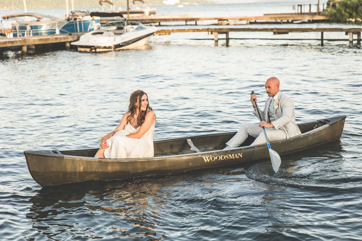 Couple enjoying a romantic canoe ride on calm waters during sunset.