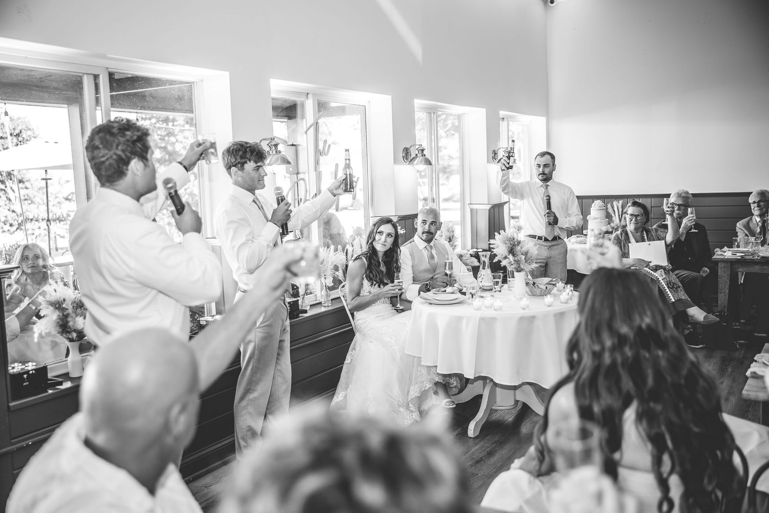 Black and white photo of wedding reception celebration with dancing guests.