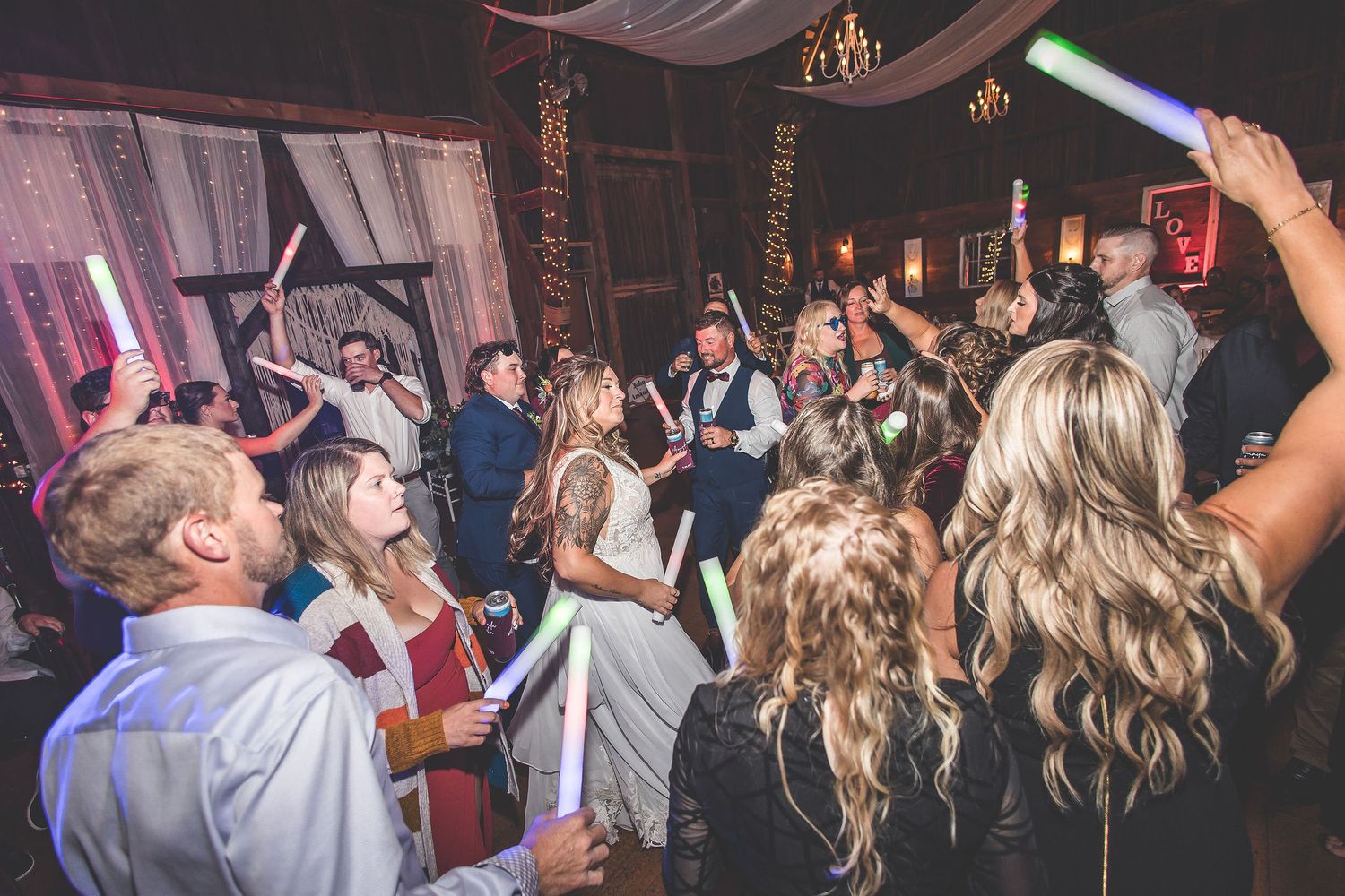 Wedding party celebration with light-up props creating a festive atmosphere on dance floor.