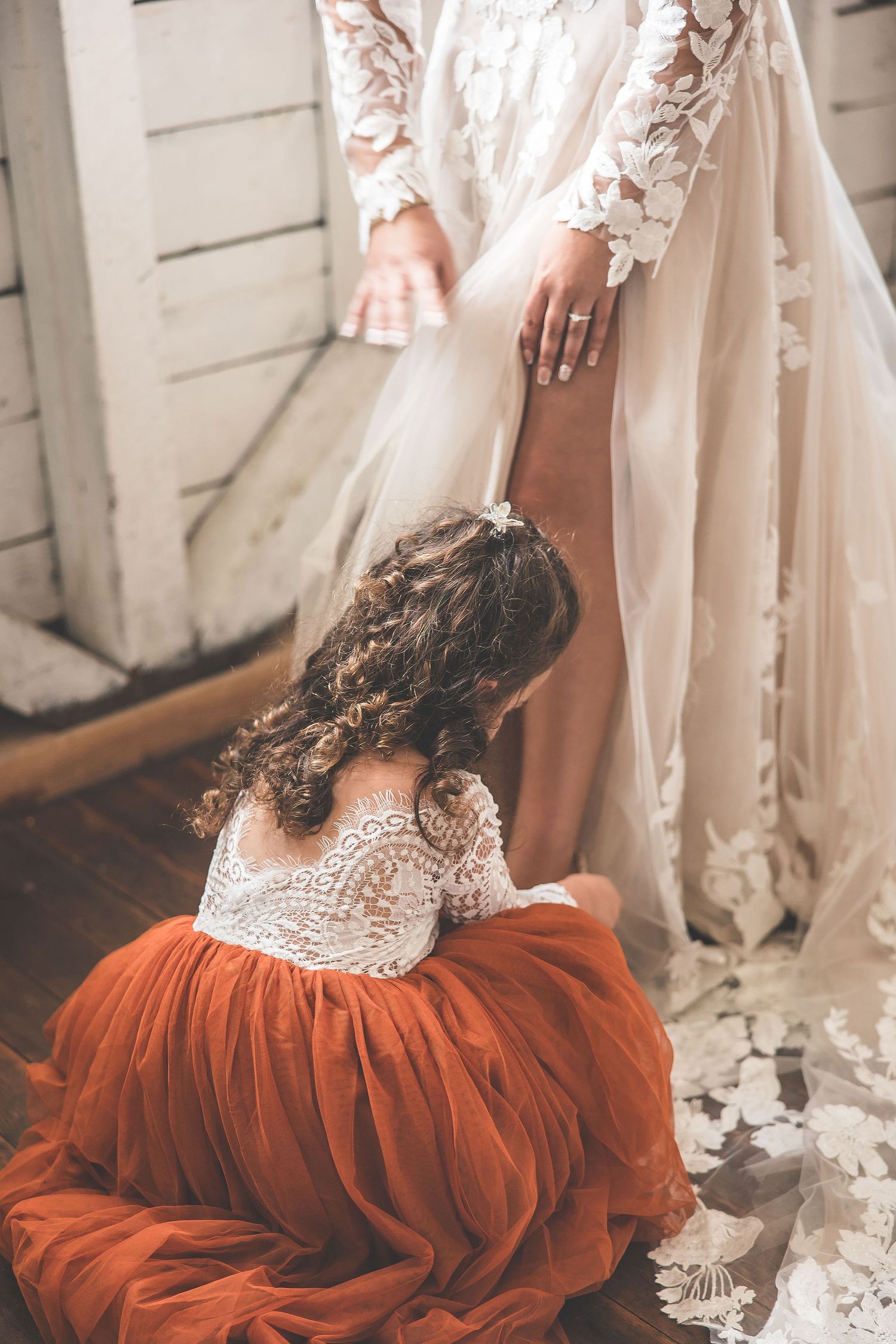 Unique bridal fashion featuring a white lace gown with burgundy tulle petticoat underneath.