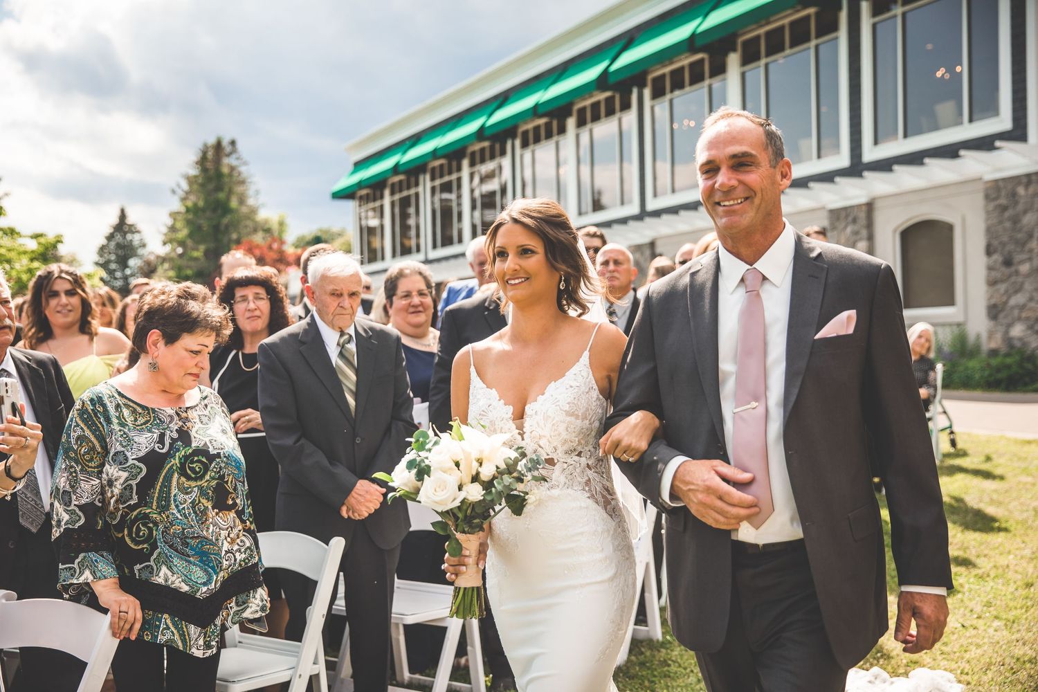 Emotional wedding celebration moments captured outside with guests and wedding party.