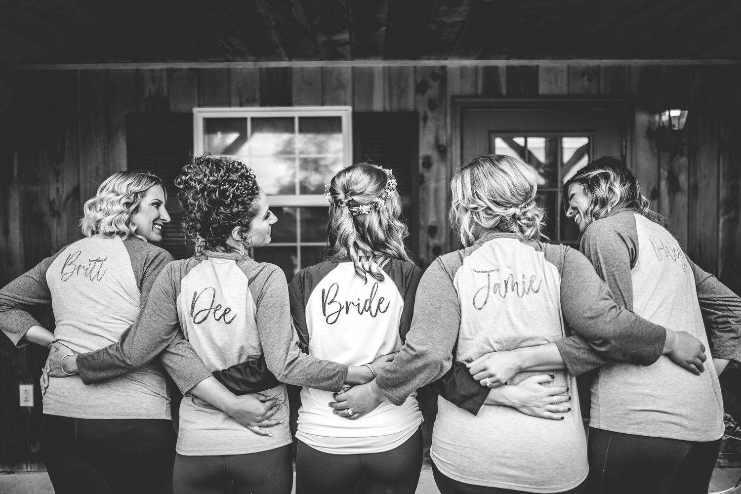 Row of matching gray sweatshirts with text displayed on backs.