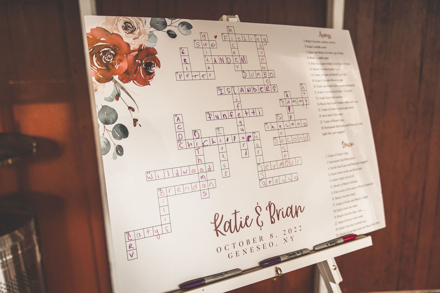 Wedding seating chart displays with handwritten names and table assignments on rustic wooden backdrop.
