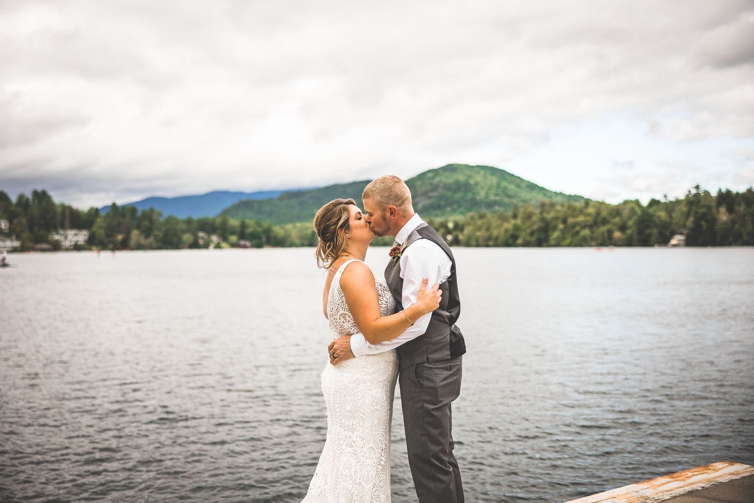 Romantic lakeside wedding portraits with mountains and water in the background.