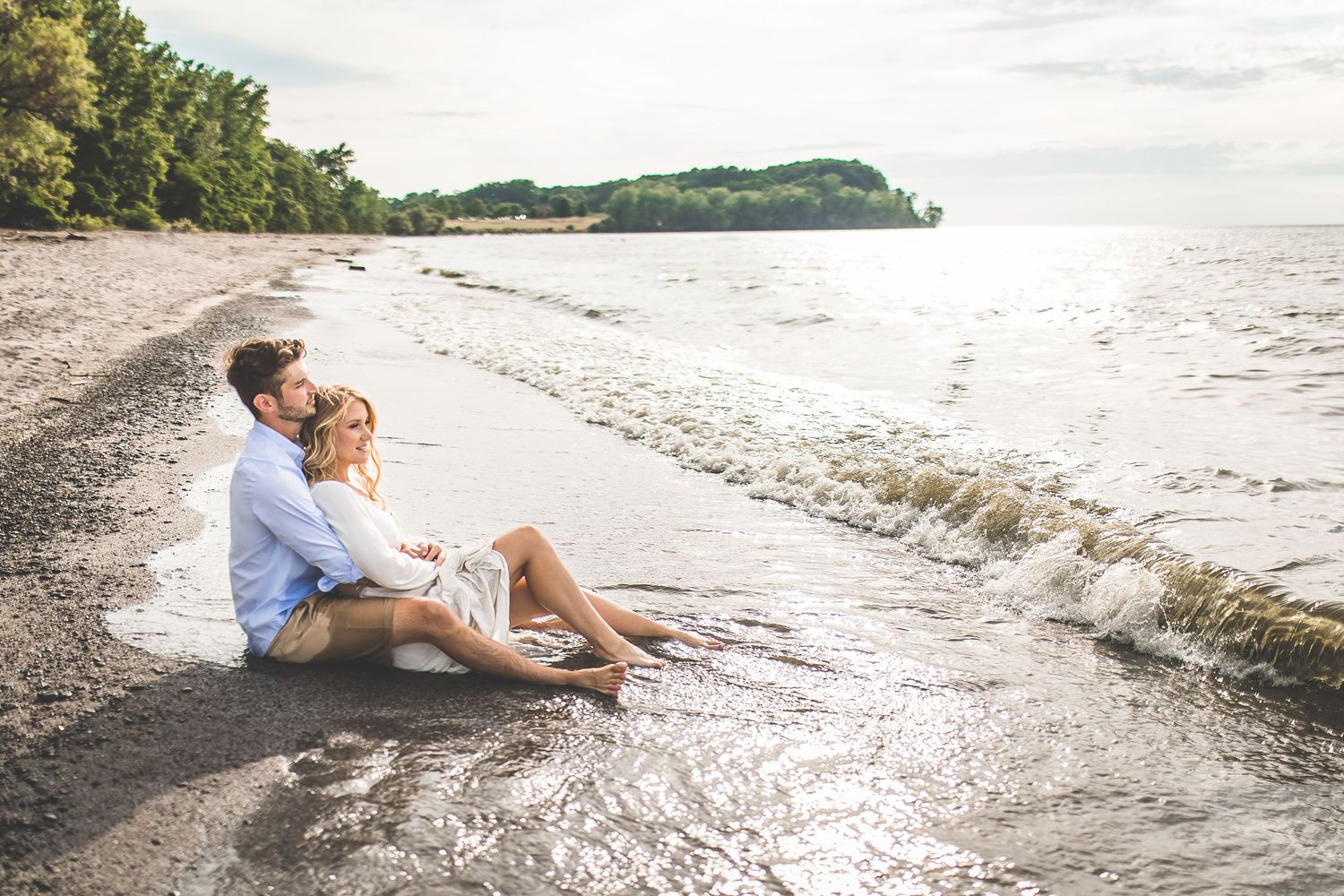 Romantic beach photoshoot with waves gently lapping at the shore during golden hour.