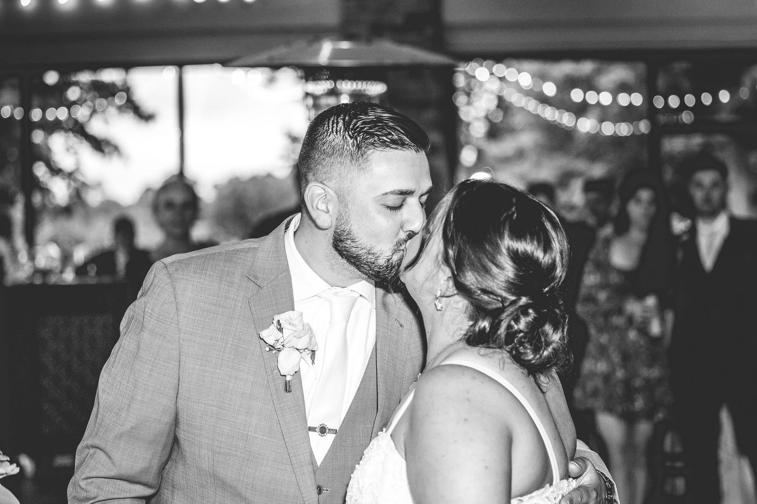String lights create a romantic ambiance during evening wedding festivities.