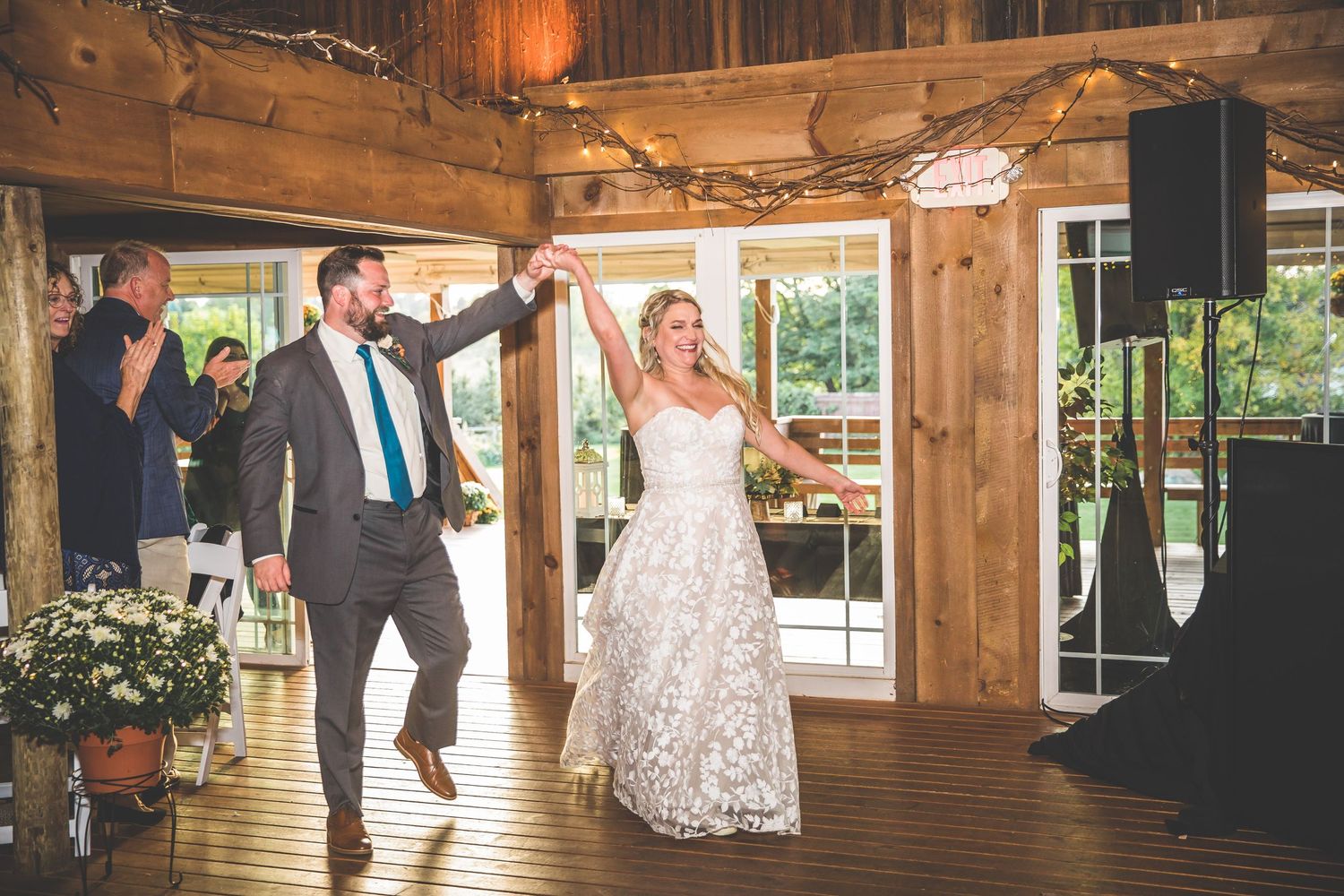 Rustic wooden barn interior decorated for wedding reception with warm lighting.