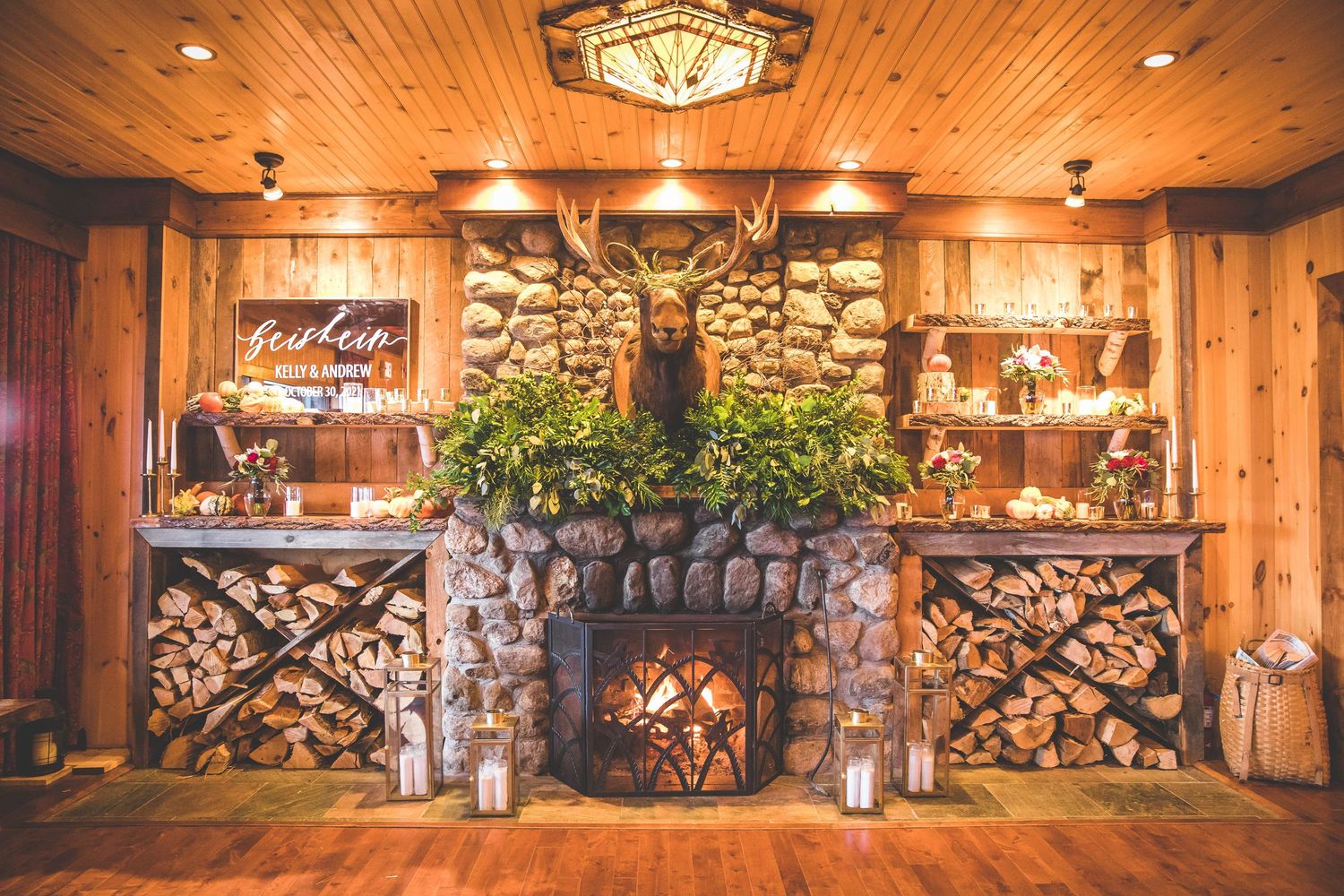 Cozy lodge interior with wood paneled ceiling, stone walls and ambient lighting for a wedding reception.