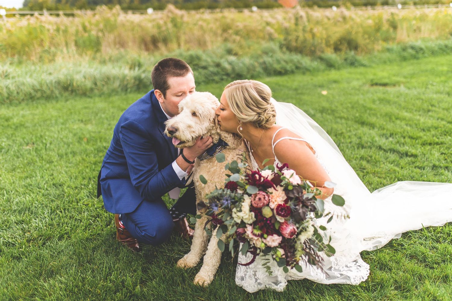 Newlyweds and their dog share candid moments during outdoor wedding portraits.
